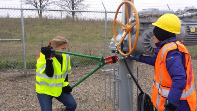 Activists are seen attempting to cut chains after trespassing into a valve station for pipelines carrying crude from Canadian oils sands into the U.S. markets near Clearbrook